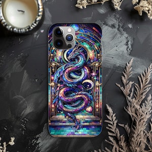 May include: A smartphone case featuring a stained-glass dragon design. The dragon is depicted in shades of blue, purple, and teal, with a crescent moon and stars. The case has a colorful, mosaic-like background and a black border.