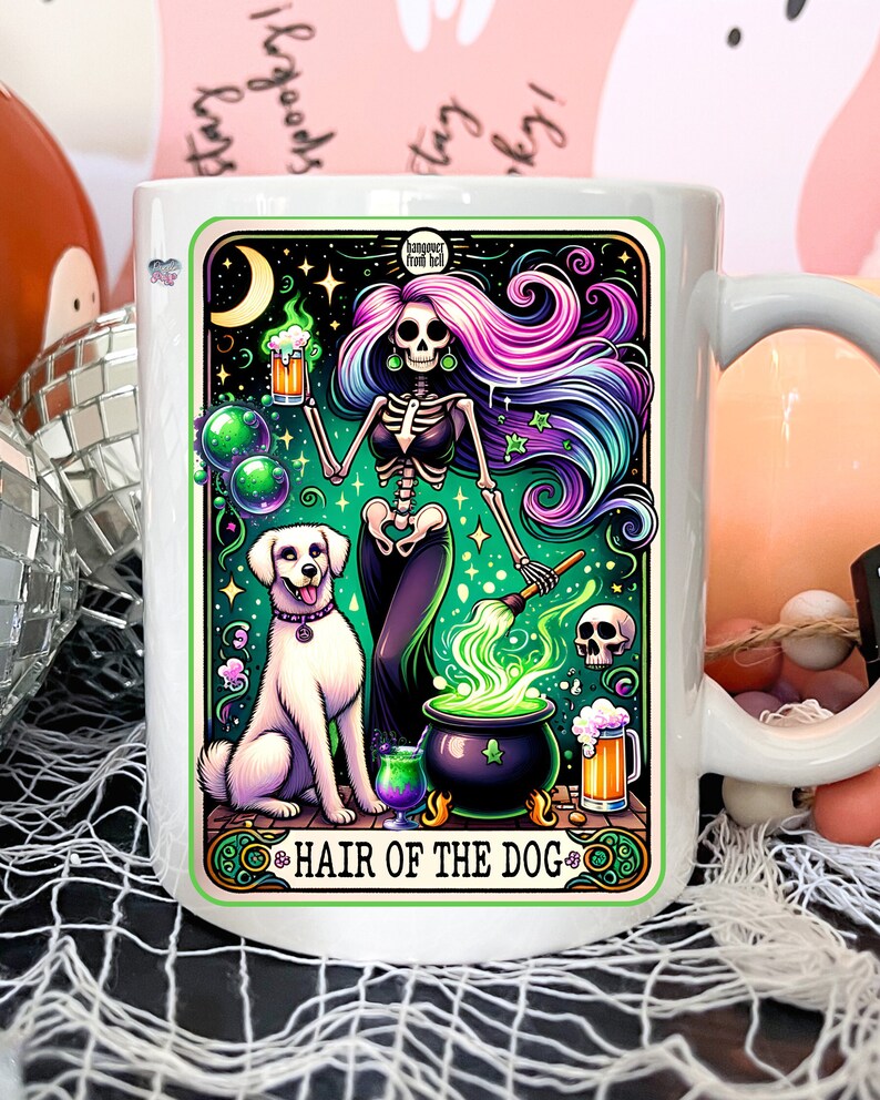 May include: White ceramic mug with a colorful illustration of a skeleton woman with long purple and blue hair, holding a beer mug and a cauldron with green smoke. A white dog stands next to her. The text "HAIR OF THE DOG" is at the bottom of the mug.