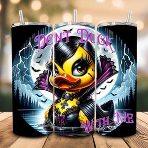 Op de afbeelding: Een zwarte en witte tumbler met een afbeelding van een gele eend die is verkleed als een vampier. De eend heeft zwart haar, een zwarte cape en een zwart-witte jurk. De tekst "Don't Duck With Me" staat op de tumbler.