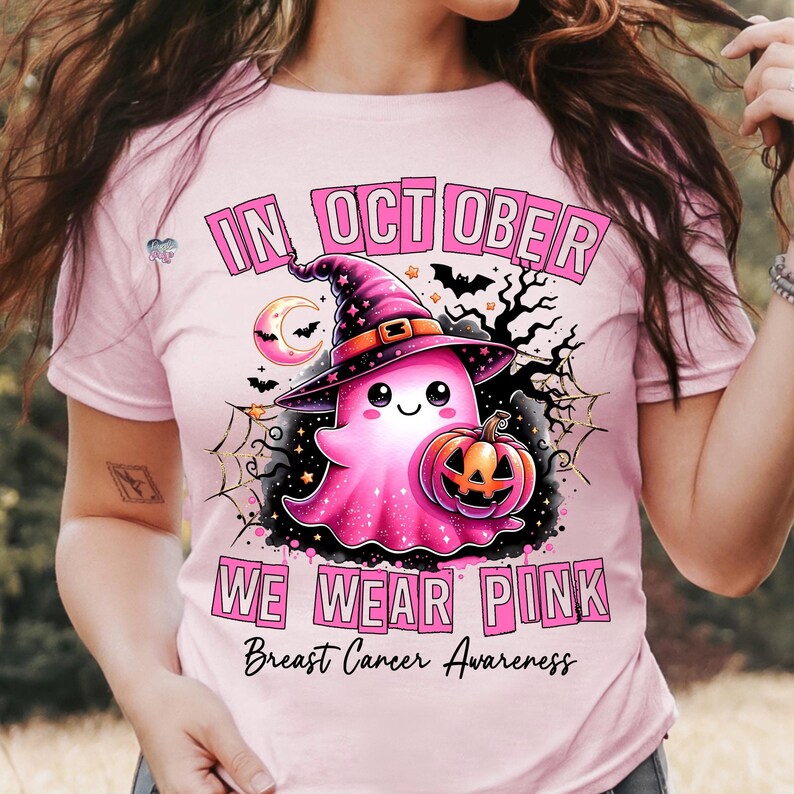 Peut inclure: T-shirt rose avec un joli fant&ocirc;me portant un chapeau de sorci&egrave;re et tenant une citrouille. Le texte sur le t-shirt est "En octobre, on porte du rose pour la sensibilisation au cancer du sein".