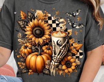 May include: Dark grey t-shirt with a fall-themed graphic. The design features sunflowers, pumpkins, bats, and a coffee cup held by a skeleton hand. The shirt has a vintage, distressed appearance.