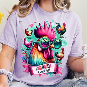 May include: A purple t-shirt with a colorful rooster wearing sunglasses and a pink ribbon that says "Not Today Cluckers!"