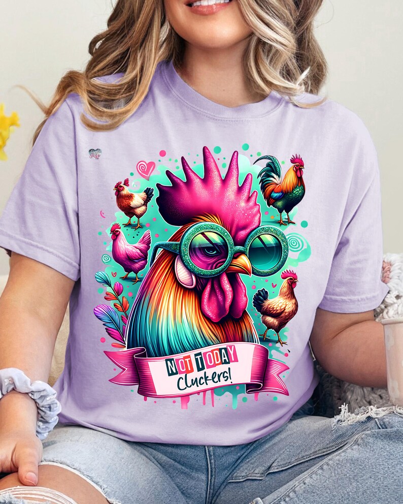 May include: A purple t-shirt with a colorful rooster wearing sunglasses and a pink ribbon that says "Not Today Cluckers!"