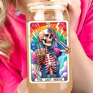 K&ouml;nnte beinhalten: Ein Glasgef&auml;&szlig; mit einem Bambusdeckel zeigt eine farbenfrohe Illustration eines Skeletts, das eine Kaffeetasse h&auml;lt. Die Illustration ist von einem Regenbogen und Blitzen umgeben. Der Text "WTF" und "THE LAST NERVE" ist auf dem Gef&auml;&szlig; aufgedruckt.