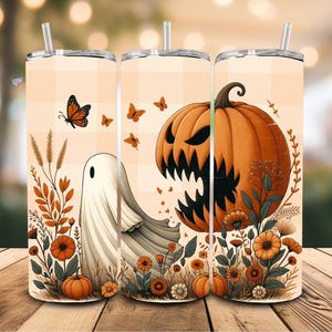 Pode incluir: Um copo com tema de Halloween com canudo. O design apresenta uma abóbora de Halloween, um fantasma, borboletas e abóboras em um fundo xadrez. O copo é decorado com folhagens e flores de outono.