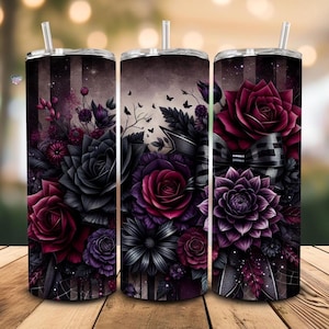 May include: Three stainless steel tumblers with floral designs. The tumblers feature a dark color palette with black, burgundy, and purple roses, dahlias, and other flowers. Each tumbler has a straw and a lid.