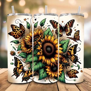 May include: Three stainless steel tumblers with a white background and a design of sunflowers, butterflies, and green leaves. The butterflies are in shades of brown, orange, and black.