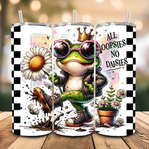 May include: A tumbler with a whimsical design featuring a cartoon frog wearing sunglasses, a crown, and a leather jacket. The frog is holding a daisy and the text "All Oopsies No Daisies" is displayed. The tumbler has a black and white checkered pattern.