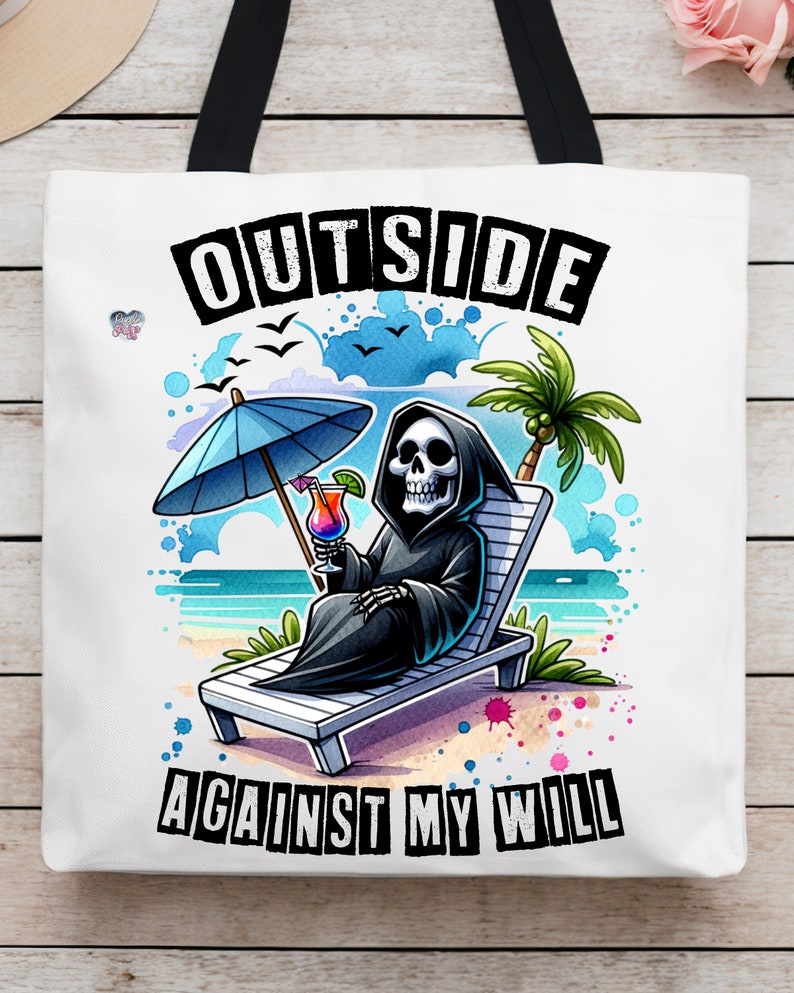 May include: A white tote bag with a black handle and a graphic of a skeleton sitting in a beach chair with a tropical drink. The text "OUTSIDE AGAINST MY WILL" is printed in black letters on the bag.