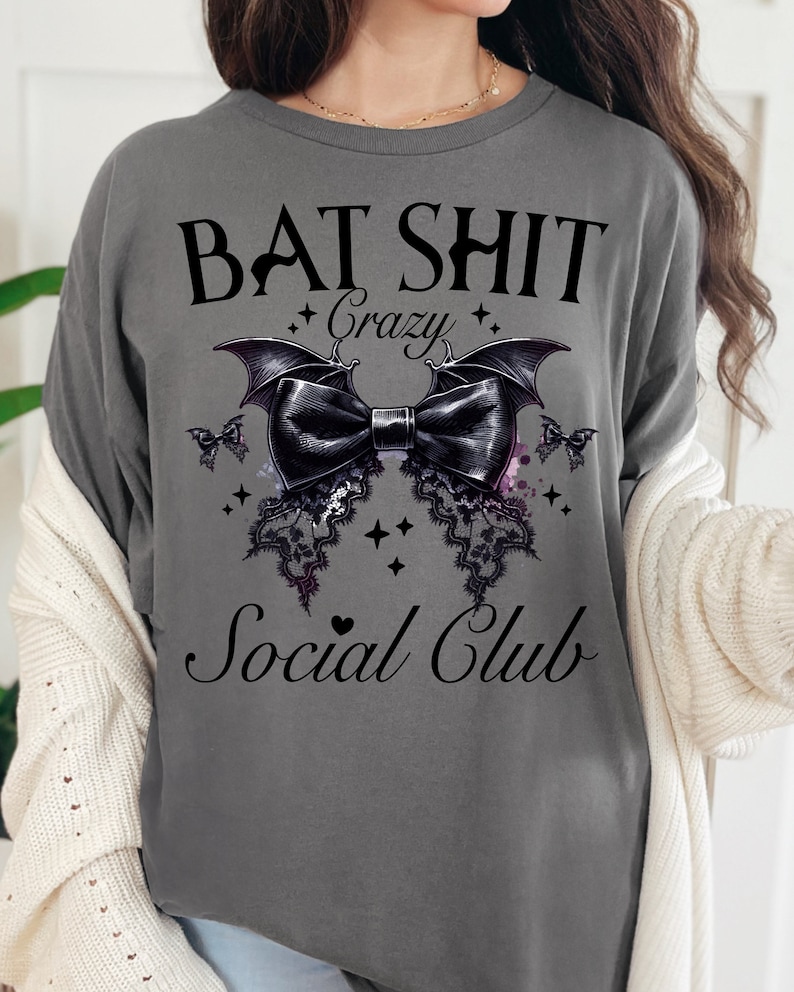 May include: Gray t-shirt with a black bat design and the text "Bat Shit Crazy Social Club".