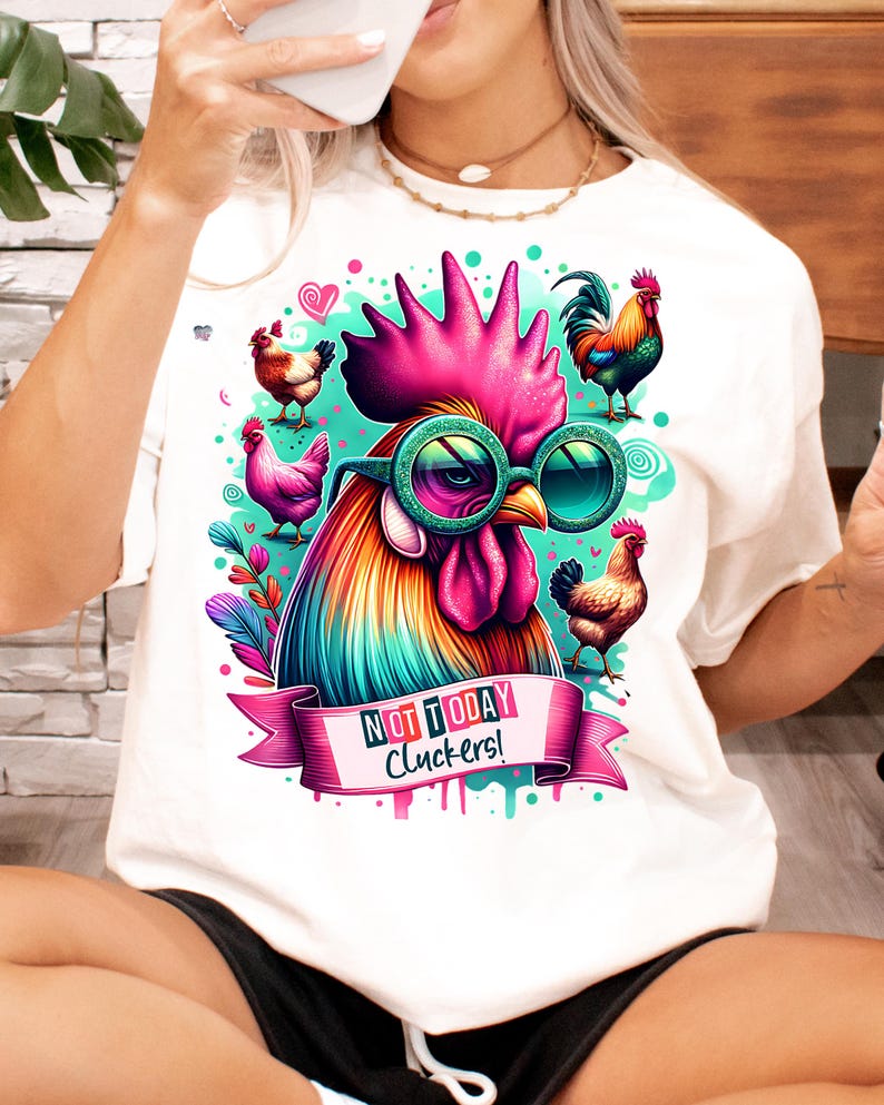 May include: White t-shirt with a colorful rooster wearing sunglasses and the text "Not Today Cluckers!" printed on it.