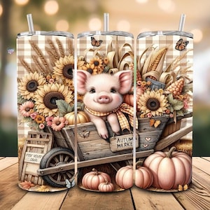 May include: A set of three stainless steel tumblers with lids and straws. Each tumbler features a whimsical autumn design with a pig in a wooden cart, sunflowers, pumpkins, and the text "Autumn Market".