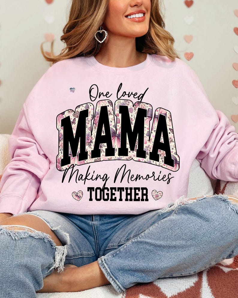 May include: Pink sweatshirt with a floral design and the text "One loved MAMA Making Memories TOGETHER" in black.
