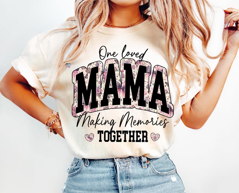 May include: A white t-shirt with a floral design and the text "One loved Mama Making Memories Together" in black.