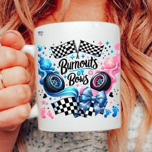 K&ouml;nnte beinhalten: Eine wei&szlig;e Keramiktasse mit einem Gender-Reveal-Design. Sie zeigt blaue und rosa Rennflaggen, Reifenspuren und eine Schleife. Der Text lautet "Burnouts or Bows".
