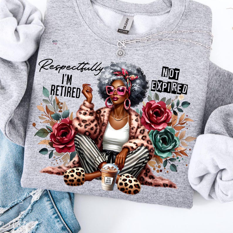 May include: A grey sweatshirt featuring a graphic of a woman in a leopard print coat, striped trousers, and pink sunglasses. The text reads "Respectfully I'M RETIRED" and "NOT EXPIRED". The design includes floral elements and a coffee cup.