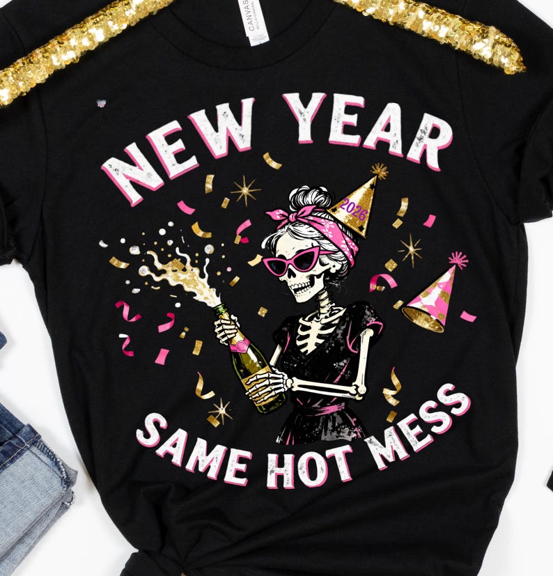 Op de afbeelding: Zwart T-shirt met een skeletafbeelding met een zonnebril en een feesthoedje, die een champagnefles ontkurkt. De tekst luidt "NEW YEAR SAME HOT MESS" in roze en wit.