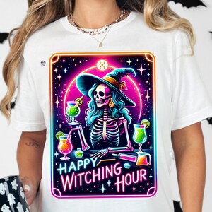 Pu&ograve; includere: Una maglietta bianca con una grafica colorata di una strega scheletro che tiene un cocktail. La grafica &egrave; in stile neon con il testo "Happy Witching Hour".