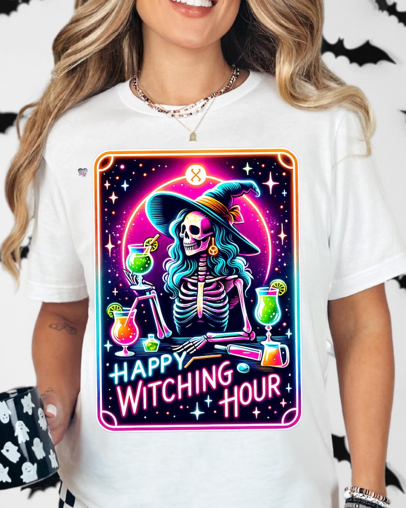 Pu&ograve; includere: Una maglietta bianca con una grafica colorata di una strega scheletro che tiene un cocktail. La grafica &egrave; in stile neon con il testo "Happy Witching Hour".