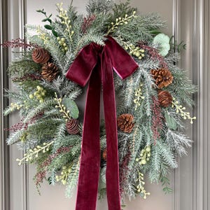 Couronne de Noël bordeaux, sapin givré, pomme de pin et nœud en velours