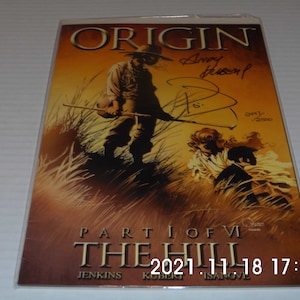 May include: A comic book cover featuring a man in a cowboy hat and a woman in a white dress. The cover is titled "Origin Part 1 of VI The Hill" and is signed by the artist, Andy Kubert. The comic book is number 341 of 3500.