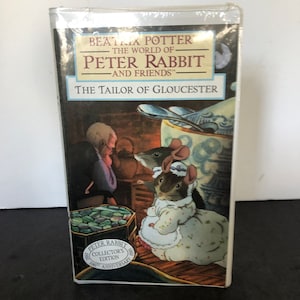May include: A sealed copy of "The Tailor of Gloucester" by Beatrix Potter, part of "The World of Peter Rabbit and Friends" series. The cover features an illustration of mice and a tailor. The book is a collector's edition celebrating the 100th anniversary.