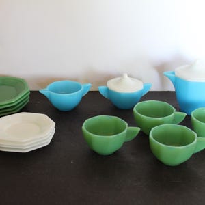 May include: A vintage children's tea set with a blue teapot, sugar bowl, and creamer, and green cups and saucers.
