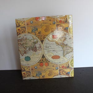 May include: A vintage-style box with a glossy finish. The box features a colorful design of antique world maps with gold accents.