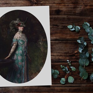 Op de afbeelding: Een vrouw in een lange, teal en roze jurk met een bloemenpatroon staat in een tuin. Ze draagt een gehoornde hoofdtooi met een schedel erop. De vrouw heeft tatoeages op haar armen en nek.
