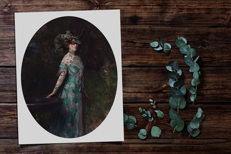 Op de afbeelding: Een vrouw in een lange, teal en roze jurk met een bloemenpatroon staat in een tuin. Ze draagt een gehoornde hoofdtooi met een schedel erop. De vrouw heeft tatoeages op haar armen en nek.