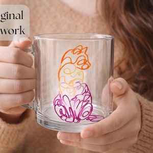 May include: Clear glass mug with a colorful cat design. The artwork features a stylized cat in shades of orange, yellow, and purple. The mug has a handle and is held by a person. The text "Original Artwork" is in the upper left corner.