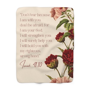 May include: Cream-colored throw blanket featuring a floral design with red and pink flowers and green leaves. The blanket has text from Isaiah 41:10, including the words "Don't fear because I am with you."