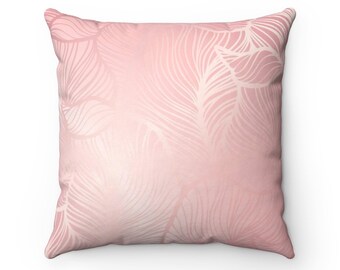 Puede incluir: Una almohada rosa con un patrón de plumas blancas. La almohada tiene una textura suave y mullida y es perfecta para agregar un toque de elegancia a cualquier habitación.