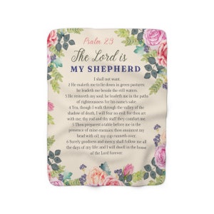 May include: A beige throw blanket with a floral design and the text "Psalm 23 The Lord is My Shepherd" and the verses of the Psalm 23. The blanket has a pink, white, and green floral design.