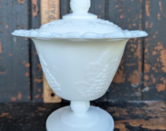 Compotier à pied en verre opalin Indiana, avec couvercle, motif raisins de récolte et bordure ajourée.