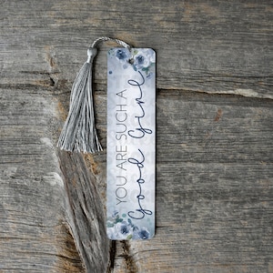 May include: A blue and white bookmark with a floral design and the text "You are such a good time". The bookmark has a silver tassel.