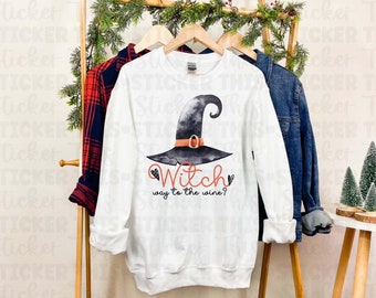 Op de afbeelding: Wit sweatshirt met een zwarte en grijze heksenhoed en de tekst "Witch way to the wine?" gedrukt op de voorkant.