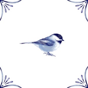May include: A square tile featuring a central illustration of a small bird with blue and white plumage, depicted in profile facing right. The corners of the tile are decorated with blue, fan-shaped floral motifs against a plain white background.