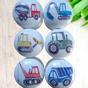 Op de afbeelding: Zes keramische knoppen met aquarel illustraties van bouwvoertuigen. De knoppen tonen een betonmixer, een graafmachine, een bulldozer, een tractor, een kraan en een kiepwagen.