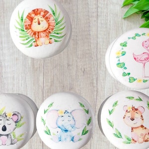 May include: A set of white ceramic cabinet knobs with watercolour illustrations of jungle animals. Designs include a lion, flamingo, koala, elephant, and tiger, each surrounded by greenery.