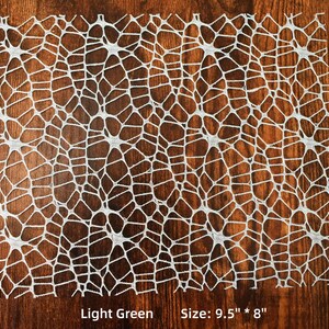Op de afbeelding: Een lichtgroene kant tafelkleed met een geometrisch patroon. Maat: 9,5" x 8"