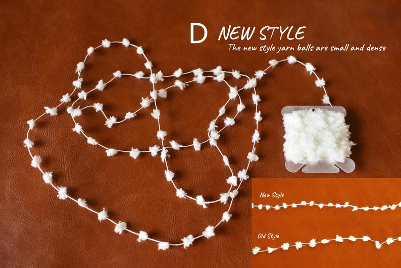 May include: White yarn balls strung together on a brown leather surface. The yarn balls are small and dense. The text "D NEW STYLE" is above the yarn balls. The text "The new style yarn balls are small and dense" is below the yarn balls. The text "New Style" and "Old Style" are below the yarn balls with a line of yarn balls next to each text label.