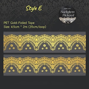 Op de afbeelding: Goudfolie PET-tape met een decoratief kantontwerp. De tape is 4,5 cm breed en 2 m lang, met een lus van 35 cm. Het ontwerp heeft bloemen en sierlijke patronen in goud tegen een donkergrijze achtergrond. De tekst "Style E" is zichtbaar.