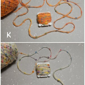 Puede incluir: Dos ovillos de hilo, uno naranja y otro multicolor, con un peque&ntilde;o carrete de hilo naranja con motas multicolores. El hilo est&aacute; sobre una superficie blanca con las letras "K" y "L" visibles.
