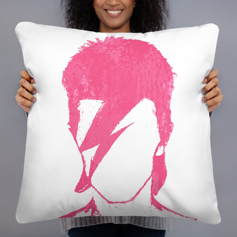 May include: White pillow with a pink silhouette of David Bowie's face with a lightning bolt across his eye.