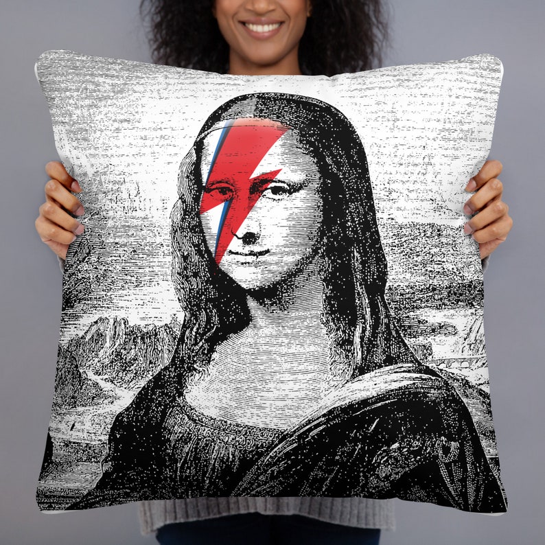 May include: Black and white illustration of the Mona Lisa with a red and blue lightning bolt painted over her eye. The image is printed on a white pillowcase.