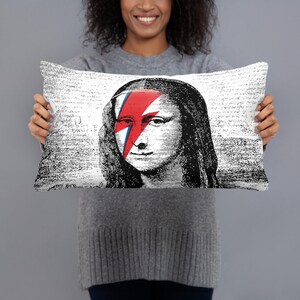 May include: A white throw pillow with a black and white image of the Mona Lisa with a red and blue lightning bolt across her face.