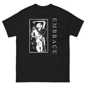 May include: Black t-shirt featuring a white graphic print of two figures embracing. The text "EMBRACE" is printed vertically on the right side of the shirt.
