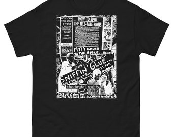 May include: Black t-shirt with a white graphic design. The design includes text and illustrations, with phrases like "Sniffin' Glue" and "How to Spot the Tell-Tale Signs." The shirt's theme appears to be related to punk rock or counter-culture.