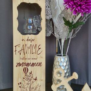 Wooden stand, wooden decorative sign, wooden sign, entrance sign with illuminated glass or solar lamp, in this family we stick together